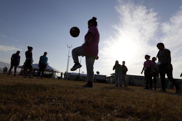 FILE- Immigrants play soccer at the U.S. government holding center for migrant children in Carrizo Springs, Texas, on July 9, 2019. (AP Photo/Eric Gay, File)