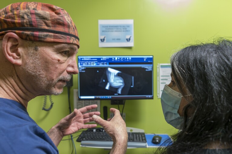 Orthopedic surgeon Dr. Scott Kozin discusses the x-ray of 4-year-old Omar Abu Kuwaik with Elissa Montanti of the Global Medical Relief Fund at Shriners Children's Hospital, Thursday, Jan. 18, 2024, in Philadelphia. (AP Photo/Peter K. Afriyie)