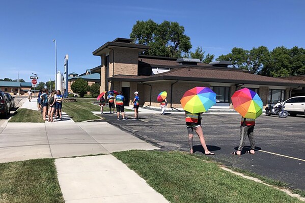 FILE - Volunteer escorts and others stand outside the Red River Women's Clinic in Moorhead, Minn., Wednesday, Aug. 10, 2022. The clinic has operated since 1998 in Fargo, where it was North Dakota's only abortion clinic. Physicians and the former, sole abortion provider in North Dakota on Tuesday, Nov. 21, 2023, asked a state district court judge for a preliminary injunction to temporarily block the state's revised abortion laws. (AP Photo/Dave Kolpack, File)