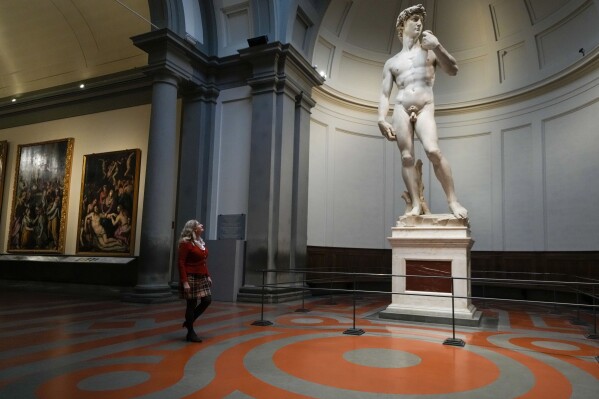Cecilie Holberg, the German director of the Accademia gallery walks past Michelangelo's 16th century statue of David on display at the Accademia gallery, in Florence, central Italy, Monday, March 18, 2024.CMichelangelo’s David has been a towering figure in Italian culture since its completion in 1504. But curators worry the marble statue’s religious and political significance is being diminished by the thousands of refrigerator magnets and other souvenirs focusing on David’s genitalia. The Galleria dell’Accademia’s director has positioned herself as David’s defender and takes swift aim at those profiteering from his image. (AP Photo/Andrew Medichini)