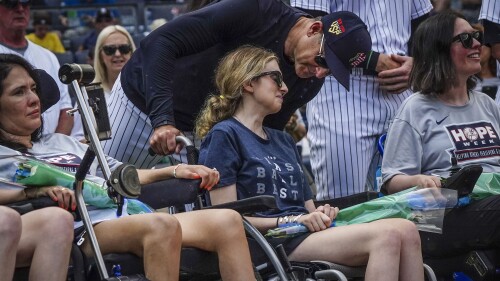 New York Yankees manager Aaron Boone, center, talk with Sarah Langs, their HOPE Week honoree, on the 84th anniversary of Lou Gehrig making his famous "Luckiest Man" speech, Tuesday, July 4, 2023, in New York. Langs, one of Major League Baseball's most respected and universally liked statistical analysts, has been in a battle with ALS the last three years. Langs and women from the organization "Her ALS Story" made a pregame tour of Monument Park and the Yankees Museum. (AP Photo/Bebeto Matthews)