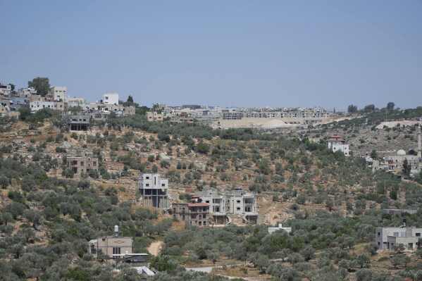A general view shows the Israeli settlement of Bruchin, center on top of a hill and adjacent to the West Bank village of Bruqin, that was under attack by Israeli settlers overnight and left several burnt vehicles and damaged homes, residents said, near Salfit, Friday, May 23, 2025. (AP Photo/Nasser Nasser)