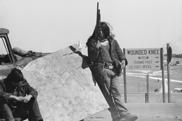 AIM guards continue to man roadblocks on roads into Wounded Knee, South Dakota, March 19, 1973, as talks between government and American Indian Movement leaders continue. AIM stated that they wanted to talk to the president or his emissary according to the Sioux Treaty of 1868. (APPhoto/Fred Jewell)