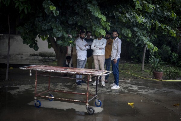 Relatives of Abhishek, who was killed in communal clashes, wait for his body outside a hospital in Nuh in Haryana state, India, Tuesday, Aug., 1, 2023. Deadly clashes between Hindus and Muslims began in the area Monday afternoon during a religious procession by a Hindu nationalist group forcing Indian authorities to impose a curfew and suspend Internet services. (AP Photo/Altaf Qadri)