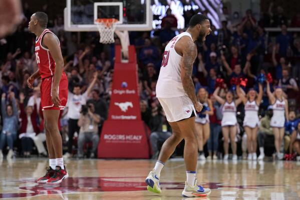 Houston's Fabian White Jr., left, looks downcourt as SMU's Marcus Weathers (50) celebrates sinking a basket late in the second half of an NCAA college basketball game in Dallas, Wednesday, Feb. 9, 2022. (AP Photo/Tony Gutierrez)