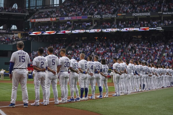FILE - The Texas Rangers stand for the playing of the national anthem before an opening day baseball game against the Philadelphia Phillies on March 30, 2023, in Arlington, Texas. An annual study reviewing diversity hiring for Major League Baseball on Thursday, June 15, reported a record low of Black players on opening-day rosters for the second straight year. (AP Photo/Jeffrey McWhorter, File)