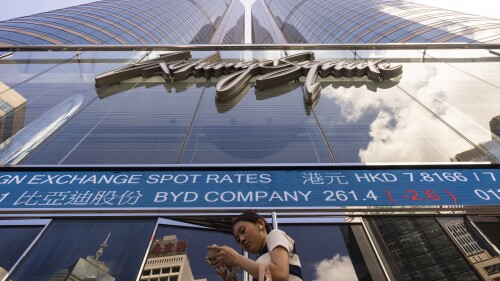 A pedestrian passes by the Hong Kong Stock Exchange electronic screen in Hong Kong, Friday, July 14, 2023. Asian shares surged Friday after Wall Street's winning streak barreled into a fourth day, buoyed by the latest signal that inflation may be easing.(AP Photo/Louise Delmotte)
