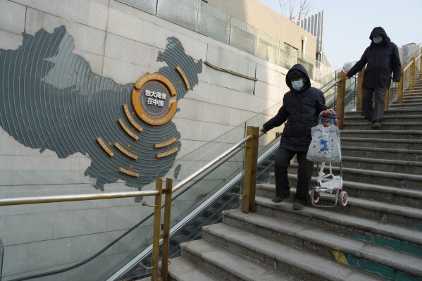 Residents walk through a partially shuttered Evergrande commercial complex in Beijing, Monday, Jan. 29, 2024. Chinese property developer China Evergrande Group on Monday was ordered to liquidate by a Hong Kong court, after the firm was unable to reach a restructuring deal with creditors. (AP Photo/Ng Han Guan)