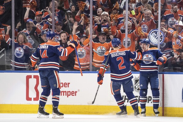 Edmonton Oilers' Mattias Ekholm (14), Evan Bouchard (2) and Zach Hyman (18) celebrate after a goal against the Los Angeles Kings during the first period of Game 1 in first-round NHL Stanley Cup playoff hockey action in Edmonton, Alberta, Monday, April 22, 2024. (Jason Franson/The Canadian Press via AP)