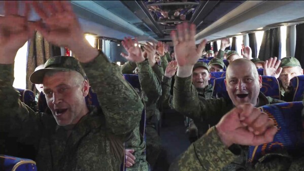 In this photo taken from video released by Russian Defense Ministry Press Service on Saturday, May 24, 2025, Russian servicemen react in a bus upon arrival to Chkalovsky airport, outside Moscow, Russia, after returning from captivity by a POWs exchange between Russia and Ukraine. (Russian Defense Ministry Press Service photo via AP)