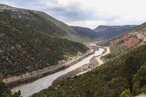 FILE - The Colorado River runs through lightly snow covered mountains April 12, 2023 near Burns, Colo. Once regularly snowbound river basins across the globe, including the upper Colorado, are increasingly seeing their snowpack shrink and climate change is to blame, a new study found. (Chris Dillmann/Vail Daily via AP, File)