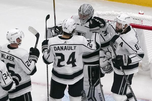 Los Angeles Kings goaltender Jonathan Quick (32) is congratulated by teammates Phillip Danault (24), Drew Doughty (8) and Sean Walker (26) following an NHL hockey game against the St. Louis Blues Monday, Oct. 31, 2022, in St. Louis. (AP Photo/Jeff Roberson)