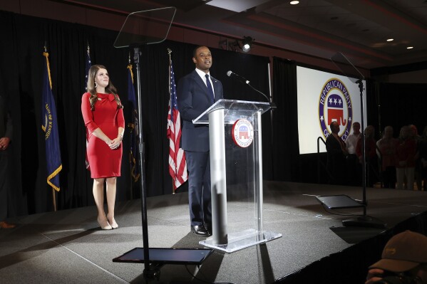 Republican gubernatorial candidate Daniel Cameron, middle, accompanied by his wife Makenze, left center, concedes to supporters during an election night watch party in Louisville, Ky., Tuesday, Nov. 7, 2023. (AP Photo/James Crisp)