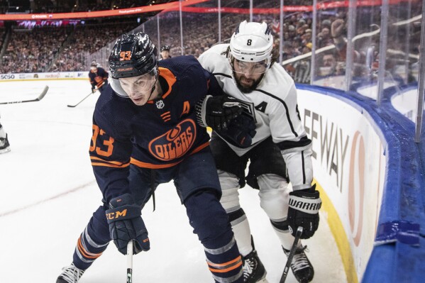 Los Angeles Kings' Drew Doughty (8) and Edmonton Oilers' Ryan Nugent-Hopkins (93) vie for the puck during the second period of an NHL hockey game Thursday, March 28, 2024, in Edmonton, Alberta. (Jason Franson/The Canadian Press via AP)