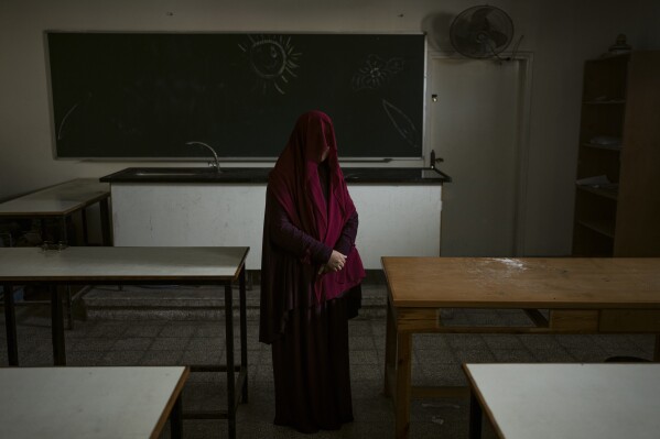 Nabela, who was detained by Israeli forces, poses for a portrait at the U.N. school where she is sheltering in Rafah, southern Gaza Strip, Friday, Feb. 23, 2024. Like many Palestinians in Gaza, Nabela thought she had found a safe place to shelter in a U.N. school. Then, the Israeli army arrived. She says soldiers stormed the school, ordering men to strip to their underwear and hauling women to a nearby mosque for strip searches. So began six harrowing weeks in Israeli custody that she says included repeated beatings and interrogations. (AP Photo/Fatima Shbair)