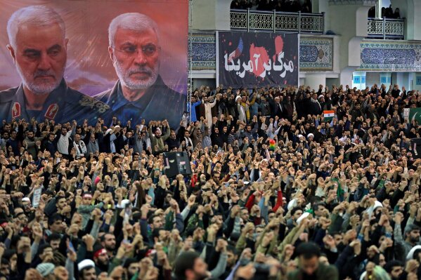 FILE - In this Jan. 17, 2020 file photo, released by the official website of the office of the Iranian supreme leader, worshippers chant slogans during Friday prayers ceremony, as a banner show Iranian Revolutionary Guard Gen. Qassem Soleimani, left, and Iraqi Shiite senior militia commander Abu Mahdi al-Muhandis, who were killed in Iraq in a U.S. drone attack on Jan. 3, and a banner which reads in Persian: "Death To America, "at Imam Khomeini Grand Mosque in Tehran, Iran. On Thursday, Jan. 7, 2021, Iraq’s judiciary issued an arrest warrant for outgoing U.S. President Donald Trump in connection with the killing of Soleimani and a al-Muhandis last year. The warrant was issued by a judge in Baghdad’s investigative court tasked with probing the Washington-directed drone strike, the court’s media office said. (Office of the Iranian Supreme Leader via AP, File)