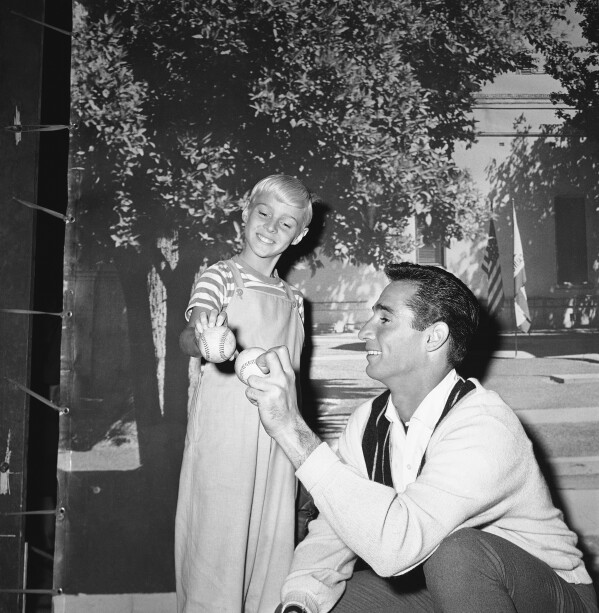 Los Angeles Dodgers pitcher Sandy Koufax, right, gives TV star Jay North some pointers on pitching, Feb. 22, 1962, in Los Angeles (AP Photo/David F. Smith, File)