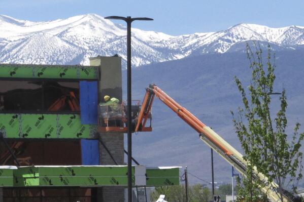 A construction worker works on the exterior of the Legends Bay Casino, Friday, May 13, 2022, in Sparks, Nev. The new casino is scheduled to open this summer at The Outlets at Legends shopping center along I-80 next to the Sparks Marina. It will be the first new casino built in the Reno-Sparks area in a quarter-century. Las Vegas-based Circa Sports will operate the sports book inside Olympia Gaming's 80,000-square-foot casino, which also will include table games, slots and video poker.  (AP Photo/Scott Sonner)