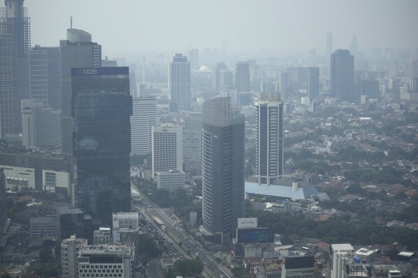 FILE - Haze blankets the main business district in Jakarta, Indonesia, Aug. 11, 2023. Earth is exceeding its “safe operating space for humanity” in six of nine key measurements of its health, and two of the remaining three, one being air pollution, are headed in the wrong direction, a new study said. (AP Photo/Dita Alangkara, File)