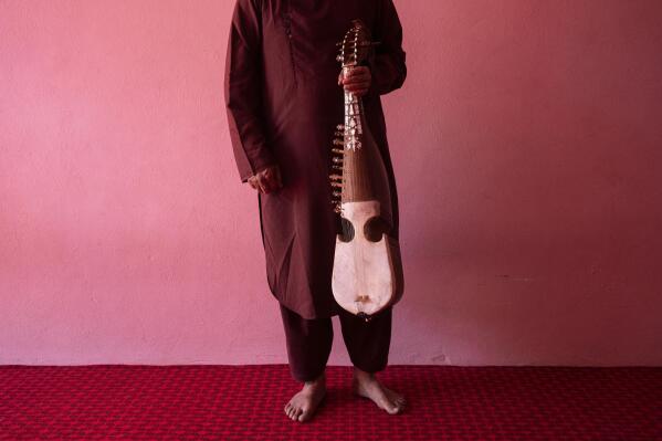 An Afghan musician poses for a portrait with his rubab in Kabul, Afghanistan, Thursday, Sept. 16, 2021. About a month after the Taliban seized power in Afghanistan, the music is starting to go quiet. The last time that the militant group ruled the country, in the late 1990s, it outright banned music. (AP Photo/Bernat Armangue)