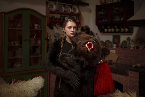 Amalia, 16 years-old, a member of the Sipoteni bear pack, poses for a portrait in Comanesti, northern Romania, Wednesday, Dec. 27, 2023. Amalia first wore the bear fur costume when she was 4 years-old, loves the team atmosphere in the bear pack and feels it's important for the centuries old tradition to live on. (AP Photo/Andreea Alexandru)
