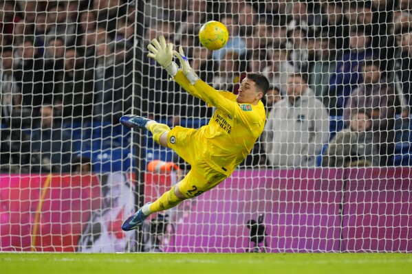 Chelsea's goalkeeper Djordje Petrovic saves a shot from Newcastle's Matt Ritchie during a penalty shoot out during the English League Cup quarterfinal soccer match between Chelsea and Newcastle United at Stamford Bridge in London, Tuesday, Dec. 19, 2023. Chelsea won the match 4-2 on a penalty shoot out after the match ended 1-1. (AP Photo/Kirsty Wigglesworth)