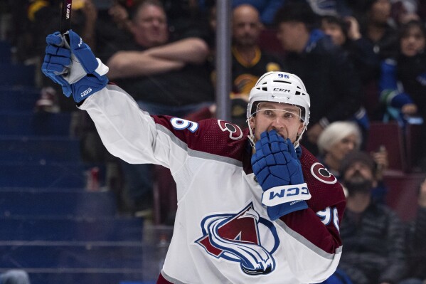 Colorado Avalanche's Mikko Rantanen celebrates Nathan MacKinnon's overtime goal against the Vancouver Canucks in an NHL hockey game Wednesday, March 13, 2024, in Vancouver, British Columbia. (Ethan Cairns/The Canadian Press via AP)