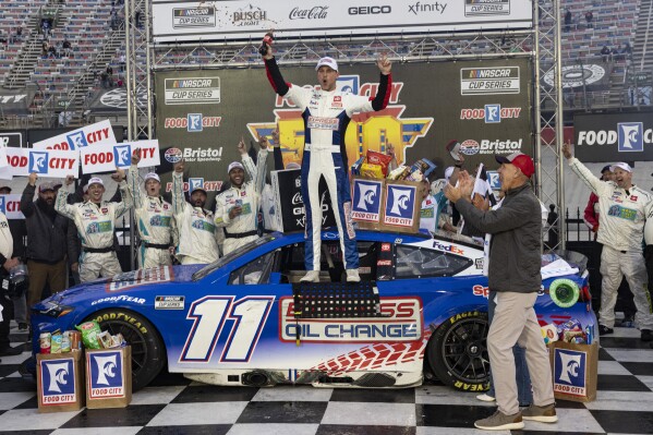 Denny Hamlin, center, celebrates after winning a NASCAR Cup Series auto race, Sunday, March 17, 2024, in Bristol, Tenn. (AP Photo/Wade Payne)