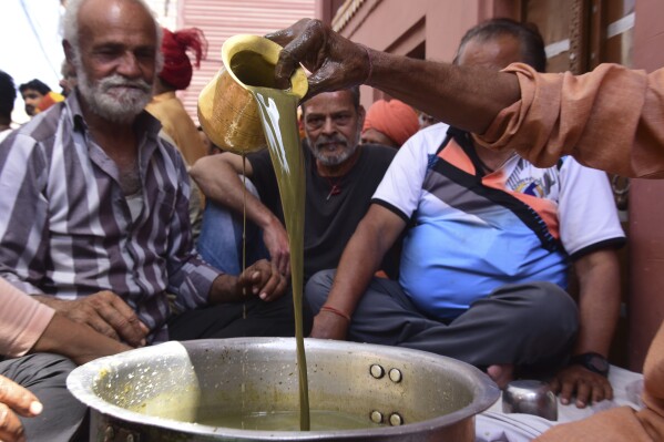 People prepare Bhang, a beverage prepared with milk, dry fruits and cannabis, during Holi festivities in Bikaner, in the Indian state of Rajasthan, India, Thursday, March 21, 2024. Holi, the Hindu festival of colors that also heralds the coming of spring, is being celebrated across the country Monday. Bhang is a popular drink during Holi. (AP Photo/Dinesh Gupta)