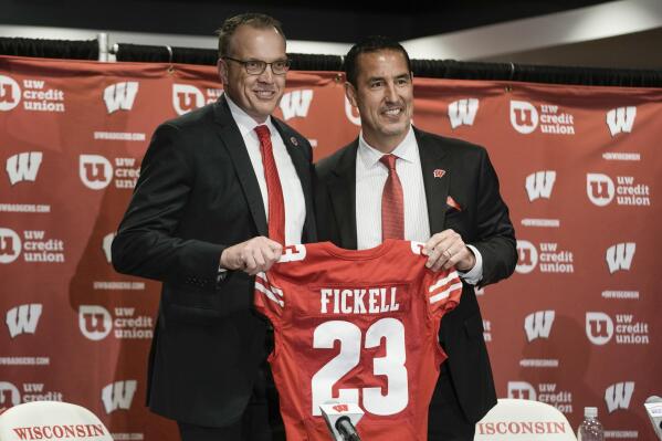 Wisconsin athletic director Chris McIntosh, left, introduces new head football coach Luke Fickell at a news conference Monday, Nov. 28, 2022, in Madison, Wis. (AP Photo/Morry Gash)
