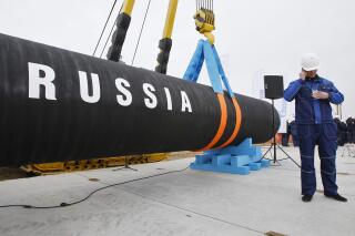 FILE - A Russian construction worker speaks on a mobile phone during a ceremony marking the start of Nord Stream pipeline construction in Portovaya Bay some 170 kms (106 miles) north-west from St. Petersburg, Russia on April 9, 2010. Russian energy giant Gazprom said Friday, Sept. 2, 2022 that it can't resume the supply of natural gas through a key pipeline to Germany for now because of what it said was a need for urgent maintenance work, just hours before it was due to recommence deliveries. Gazprom said it had identified oil leaks from four turbines at the Portovaya compressor station at the Russian end of the pipeline, including the sole operational one. (AP Photo/Dmitry Lovetsky, File)