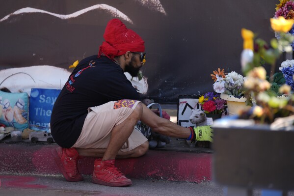 A person visits the spot of George Floyd's murder at George Floyd Square on the five-year anniversary of Floyd's death, Sunday, May 25, 2025, in Minneapolis. (AP Photo/Abbie Parr)