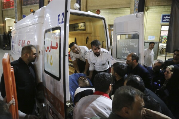 In this photo provided by Islamic Republic News Agency, IRNA, medics carry a wounded man into an ambulance after an attack at the Shah Cheragh shrine in the southern city of Shiraz, Iran, Sunday, Aug. 13, 2023. A gunman opened fire Sunday night at a prominent shrine in southern Iran, wounding at least four people, authorities said. Information on the attack at Shah Cheragh remained unclear immediately after the shooting, with state media and semiofficial news agencies offering differing details. (Reza Ghaderi, IRNA via AP)