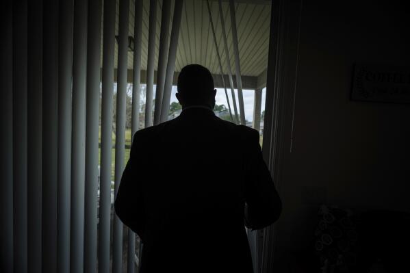 FILE - Joseph Moore looks out of a window at his home in Jacksonville, Fla., on Tuesday, Dec. 7, 2021. Moore worked for nearly 10 years as an undercover informant for the FBI, infiltrating the Ku Klux Klan in Florida, foiling at least two murder plots, according to investigators, and investigating ties between law enforcement and the white supremacist organization. "From where I sat, with the intelligence laid out, I can tell you that none of these agencies have any control over any of it. It is more prevalent and consequential than any of them are willing to admit." (AP Photo/Robert Bumsted, File)