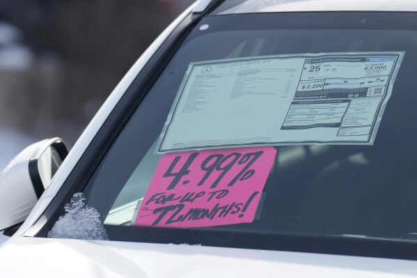 FILE - A sign highlighting the financing interest rate is displayed near the price sticker on an unsold 2023 vehicle at a Mercedes-Benz dealer on Nov. 30, 2023, in Loveland, Colo. The Federal Reserve’s decision Wednesday, May 1, 2024 to keep its benchmark rate at a two-decade high should have ripple effects across the economy. Mortgage rates, credit card rates, and auto loan rates will all likely maintain their highs, with consequences for consumer spending. (Ǻ Photo/David Zalubowski, file)