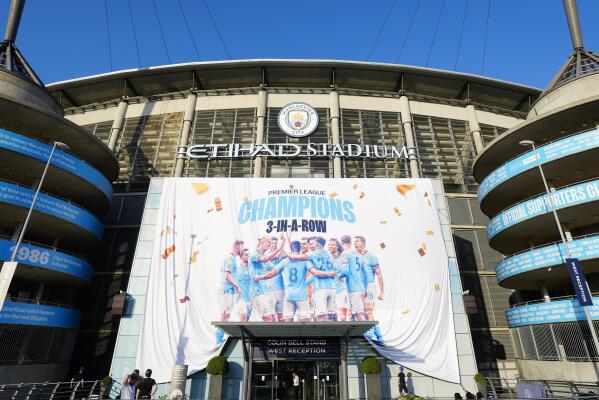 A banner celebrating their title win is unfurled outside Manchester City's Etihad stadium in Manchester, England, Saturday, May 20, 2023. Manchester City clinched the English Premier League title on Saturday after their nearest challengers Arsenal lost 1-0 to Nottingham Forest. (AP Photo/Jon Super)