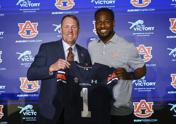 Newly named Auburn football coach Hugh Freeze, left, and Carnell Williams, who will stay on as running backs coach and associate head coach, pose for photos at a news conference Tuesday, Nov. 29, 2022, in Auburn, Ala. (AP Photo/Todd Van Emst)
