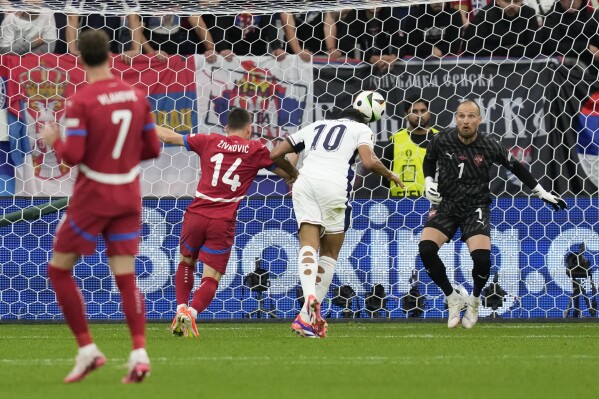 England's Jude Bellingham (10) scores on a header during the first half in a Group C match between Serbia and England at the Euro 2024 soccer tournament in Gelsenkirchen, Germany, Monday, June 17, 2024. (AP Photo/Thanassis Stavrakis)