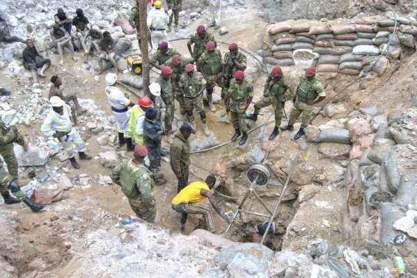 Zambian Army special forces officers follow the rescue operation of miners on Sunday, Dec. 3, 2023 in Chingola, around 400 kilometres (248 miles) north of the capital Lusaka, Zambia. Seven miners were confirmed dead and more than 20 others were missing and presumed dead after heavy rains caused landslides that buried them inside tunnels they had been digging illegally at a copper mine in Zambia, police and local authorities said Saturday. (AP Photo)