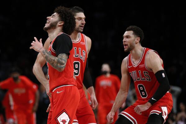 Chicago Bulls guard Lonzo Ball (2) celebrates with Nikola Vucevic (9) and Zach LaVine (8) after making a 3-point shot against the Brooklyn Nets during the second half of an NBA basketball game in New York, Saturday, Dec. 4, 2021. The Bulls won 111-107. (AP Photo/Noah K. Murray)