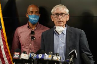 FILE - In this Aug. 27, 2020, file photo, Wisconsin Gov. Tony Evers speaks during a news conference in Kenosha, Wis. Wisconsin health officials and Gov. Evers announced Wednesday, Oct. 7, 2020, that they've opened a field hospital at the state fairgrounds near Milwaukee as a surge in COVID-19 cases threatens to overwhelm hospitals. Wisconsin has become a hot spot for the disease over the last month, ranking third nationwide this week in daily new cases per capita. (AP Photo/Morry Gash, File)