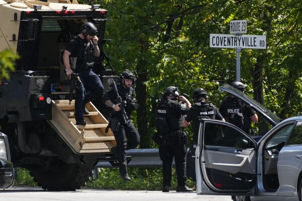 Law enforcement officers gather as the search for escaped convict Danilo Cavalcante continues Tuesday, Sept. 12, 2023, in Pottstown, Pa. (AP Photo/Matt Rourke)