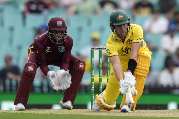 Australia's Sean Abbott, right, plays a shot in front of the West Indies' Shai Hope during their one day international cricket match in Sydney, Sunday, Feb. 4, 2024. (AP Photo/Rick Rycroft)
