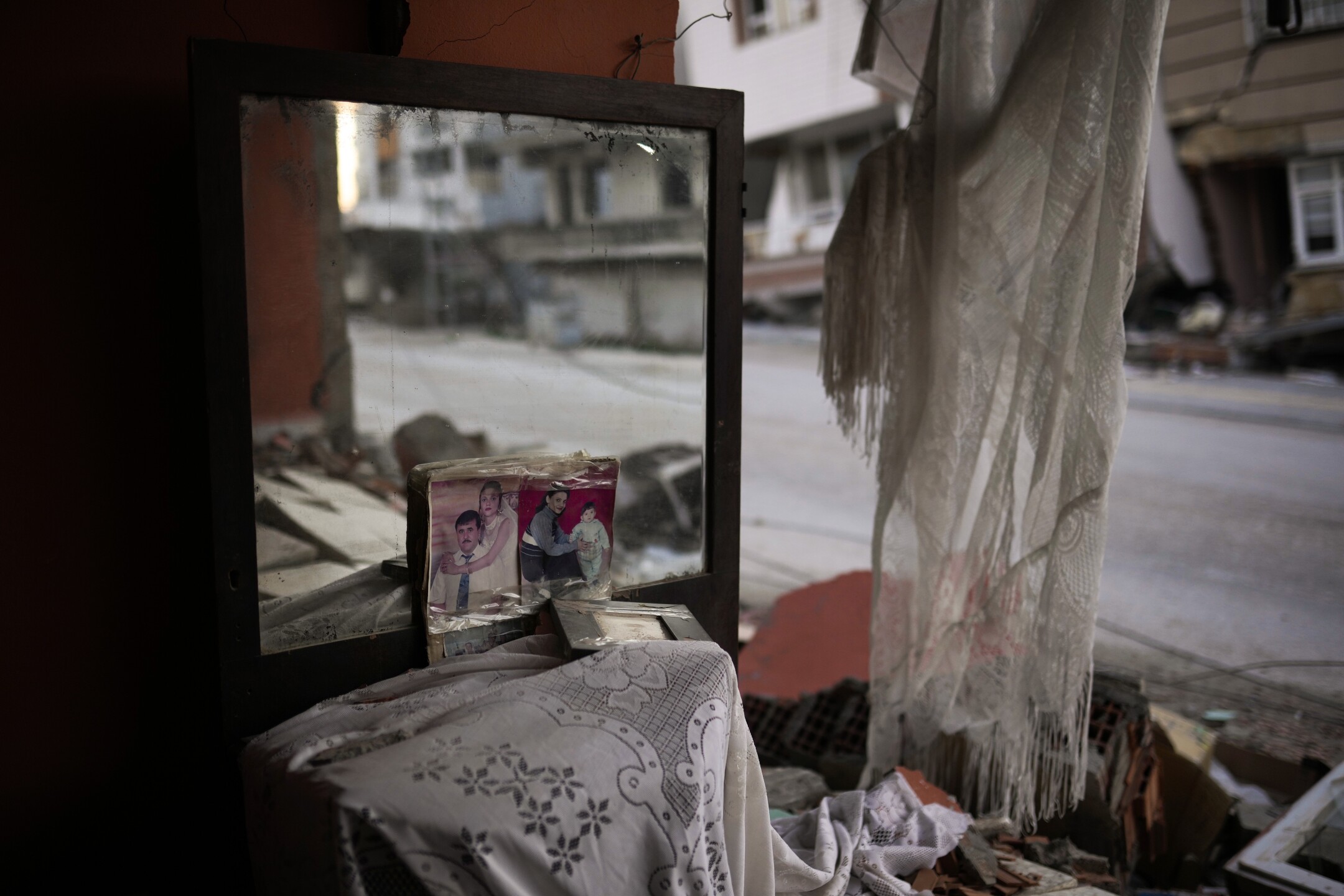 Photographs lean against a mirror in the room of a destroyed house in Samandag, southern Turkey, on Feb. 16, 2023, after the earthquake struck the area. (AP Photo/Francisco Seco)