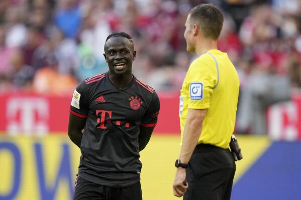 Bayern's Sadio Mane talks with Referee Harm Osmers while waiting for a VAR decision during the German Bundesliga soccer match between FC Bayern Munich and VfL Wolfsburg in Munich, Germany, Sunday, Aug. 14, 2022. (AP Photo/Matthias Schrader)