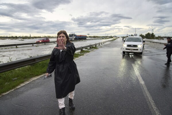Argentina's Security Minister Patricia Bullrich directs traffic along a flooded highway while overseeing emergency response efforts after heavy rains in Campana, Argentina, Saturday, May 17, 2025. (AP Photo/Rodrigo Abd)