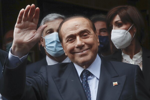 FILE - Former Italian Premier Silvio Berlusconi waves to reporters as he arrives at the Chamber of Deputies to meet Mario Draghi, in Rome, Feb. 9, 2021. Berlusconi, a cruise-ship singer, media mogul and three-time premier who dominated Italian politics for three decades, is getting a new act following his death last year. Milan’s Malpensa Airport, Italy’s second-busiest passenger airport, is being renamed for the billionaire businessman-turned-politician, Italy’s transport minister announced Thursday July 11, 2024. (AP Photo/Alessandra Tarantino, File)