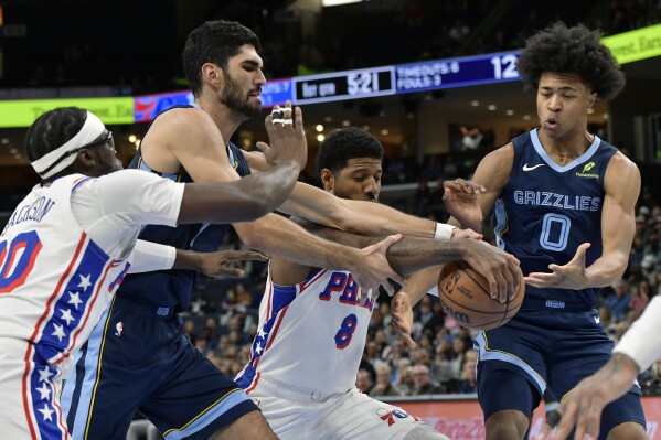 Philadelphia 76ers guard Reggie Jackson (00), Memphis Grizzlies forward Santi Aldama (7), forward Paul George (8), and forward Jaylen Wells (0) struggle for control of the ball in the first half of an NBA basketball game Wednesday, Nov. 20, 2024, in Memphis, Tenn. (AP Photo/Brandon Dill)