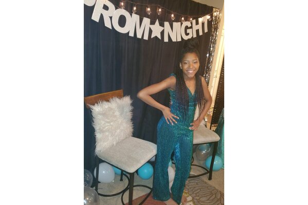 This photo shows Serenity Cadogan, 12, in Covington, Georgia, dressed for a virtual prom she hosted March 31 on National Prom Day for more than 600 young people around the world. With the Class of 2020 missing out on so many traditions due to the coronavirus pandemic, many have gone online to participate in virtual proms. (Tiffany Cadogan via AP)