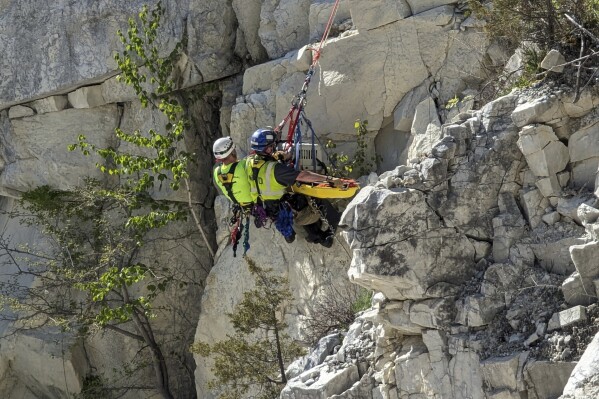 Firefighters ripple down a cliff as they rescuing Rippy, a 30-pound terrier mix dog, Tuesday, May 7, 2024, in North Canaan, CT. (Lindsay Burr/North Canaan Animal Control via AP)